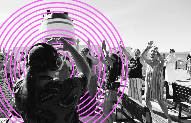 A group of people on a cruise ship, many wearing headphones, appear to be dancing. There is a distinctive pink spiral graphic overlay on the image. The setting is on a deck with benches and is under a clear sky.